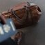 brown leather bag with out-of-focus passport in foreground