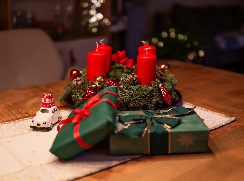 Christmas gifts laid out in front of candles