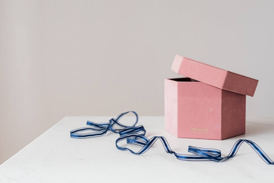 pink gift box next to blue ribbon