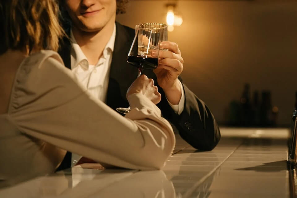 un homme et une femme lèvent leurs verres pour un toast
