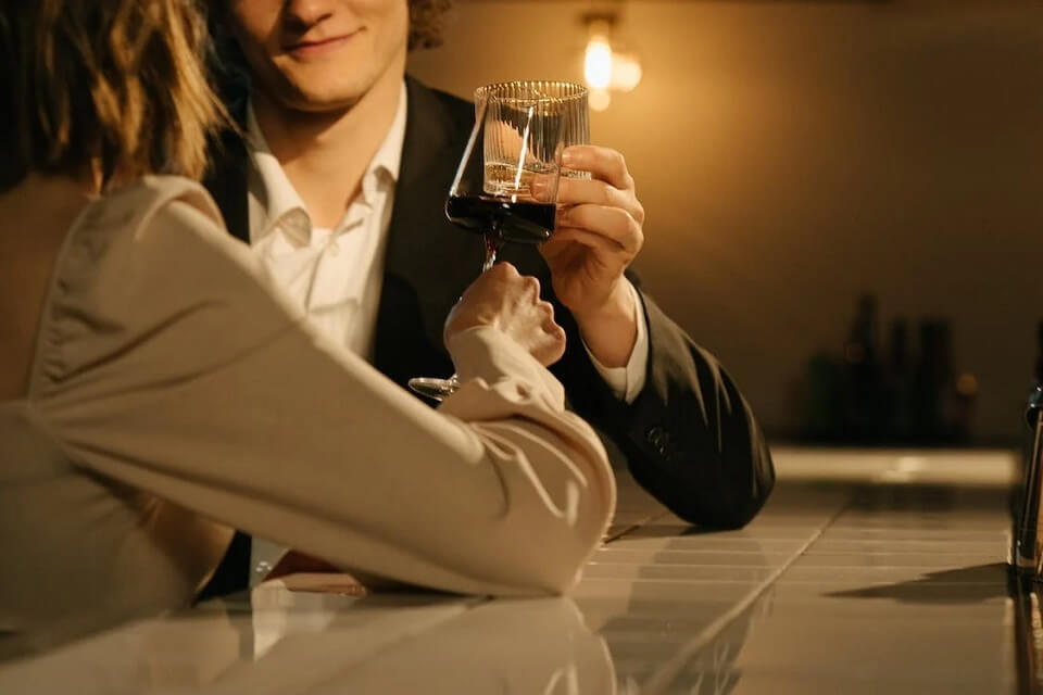 man and woman raising their drinks for a toast